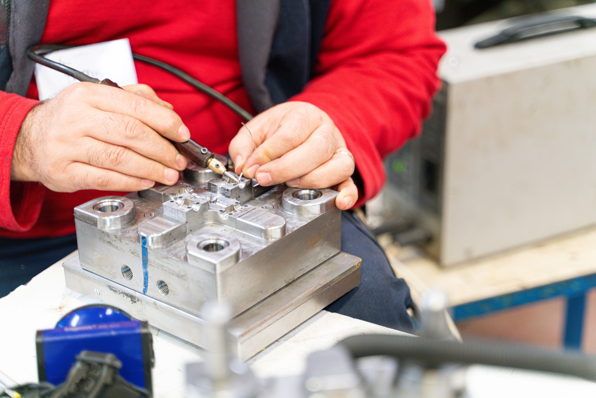 Professional technical worker man working and metal mold and die part repair in a factory.