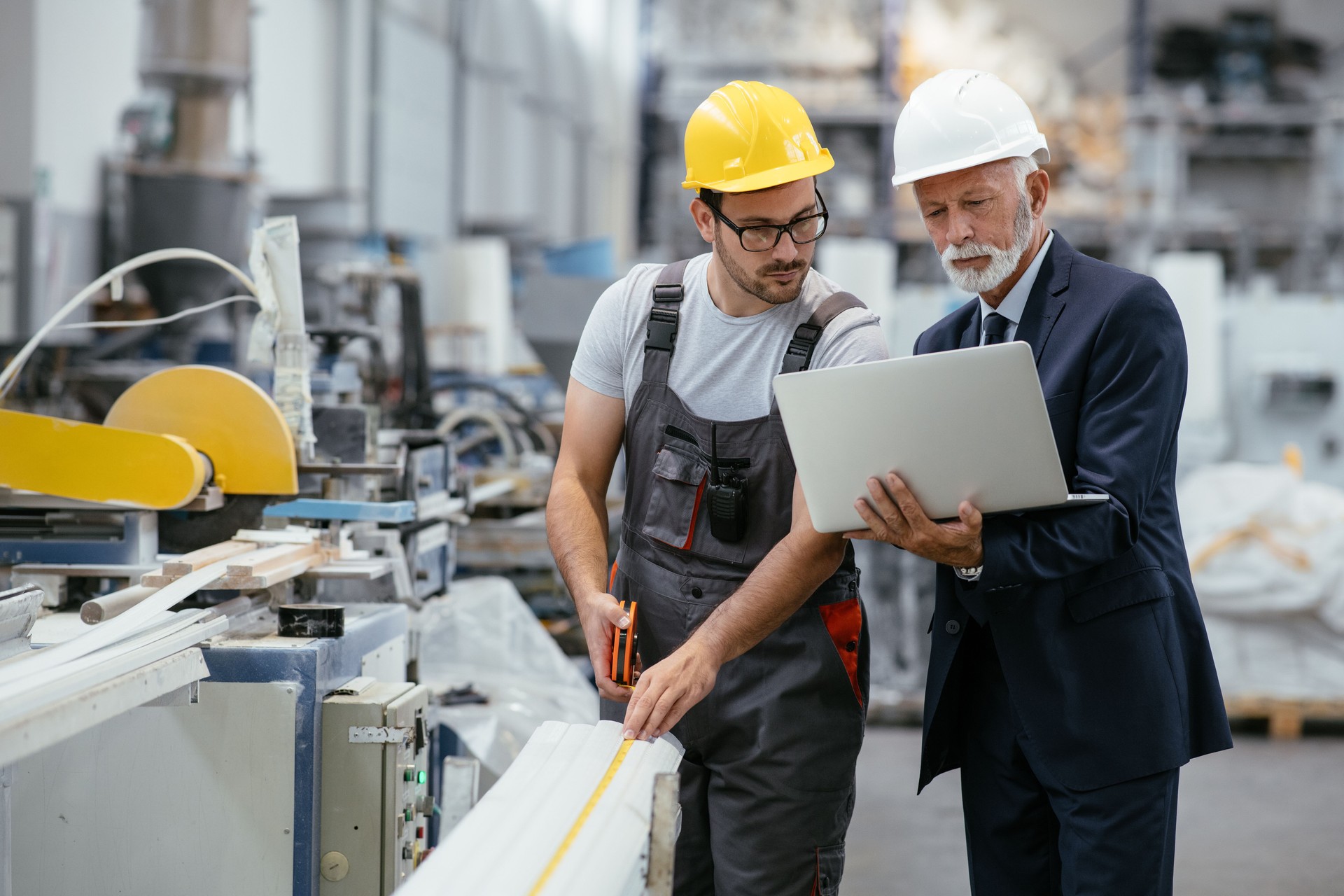 Young engineer with quality control inspector in factory